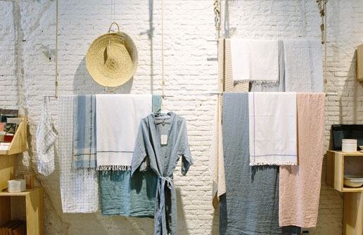 Clothing and towels hanging in a bright boutique