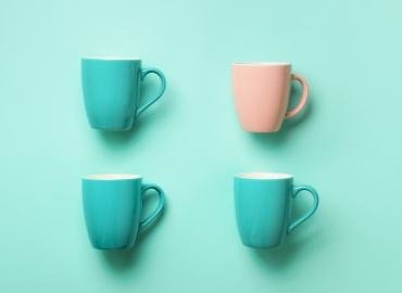 Four teal and pink cups on a teal background