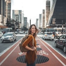 A young woman walking down a city street, looking at her phone